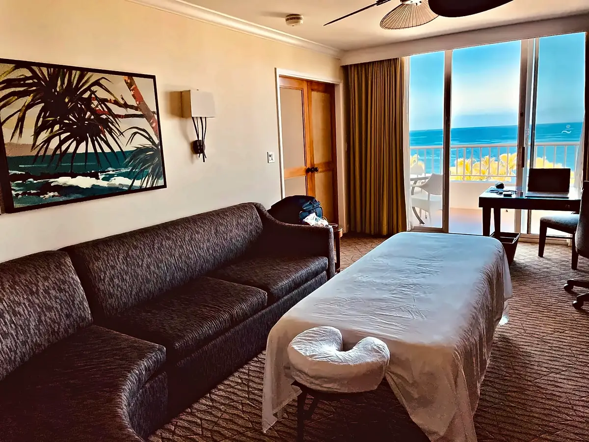 Massage table set up inside a hotel suite with ocean view in Maui