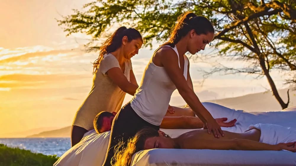 Couples massage at sunset overlooking the Maui coastline